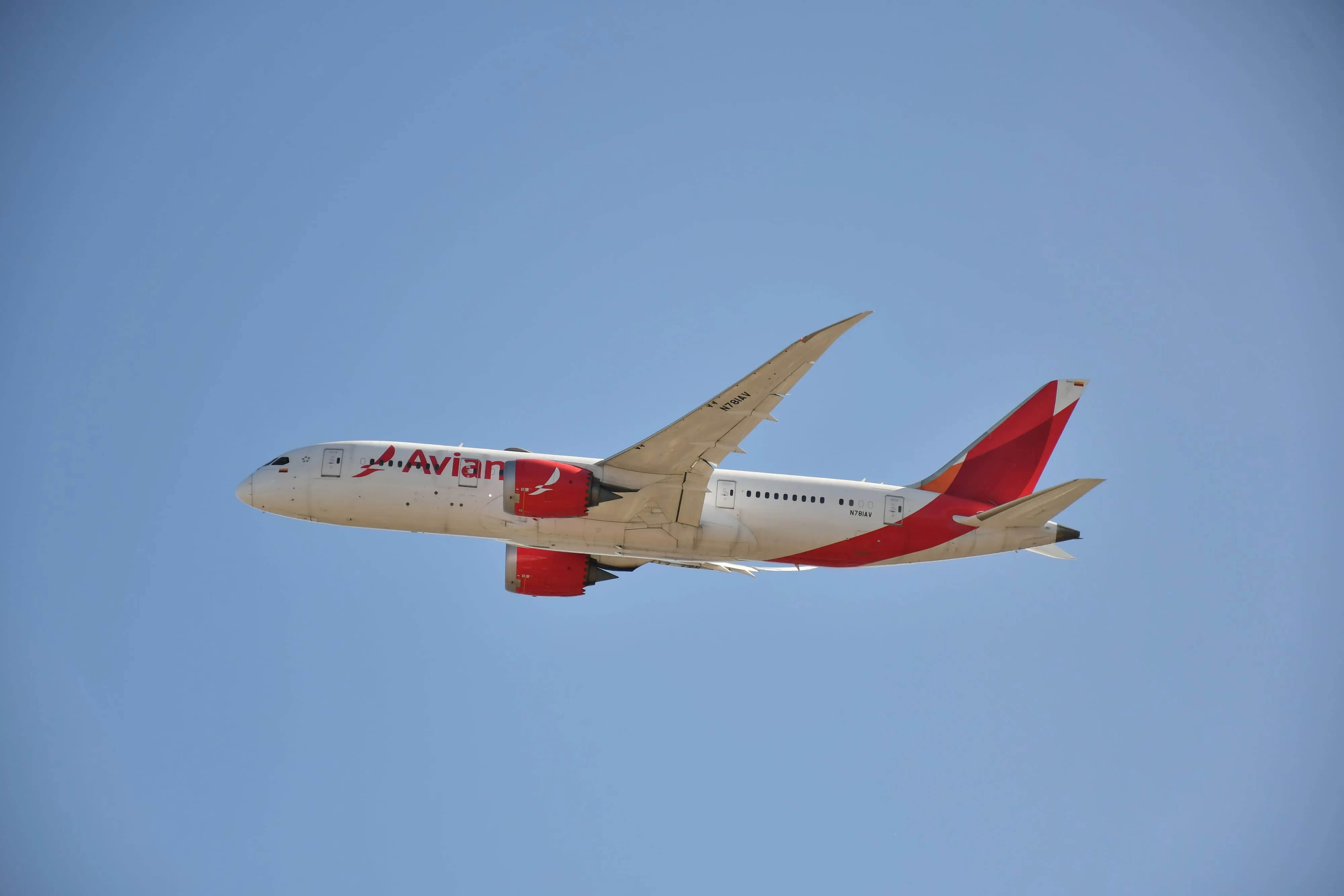 An Avianca Boeing 787 climbing away after takeoff against a clear blue sky