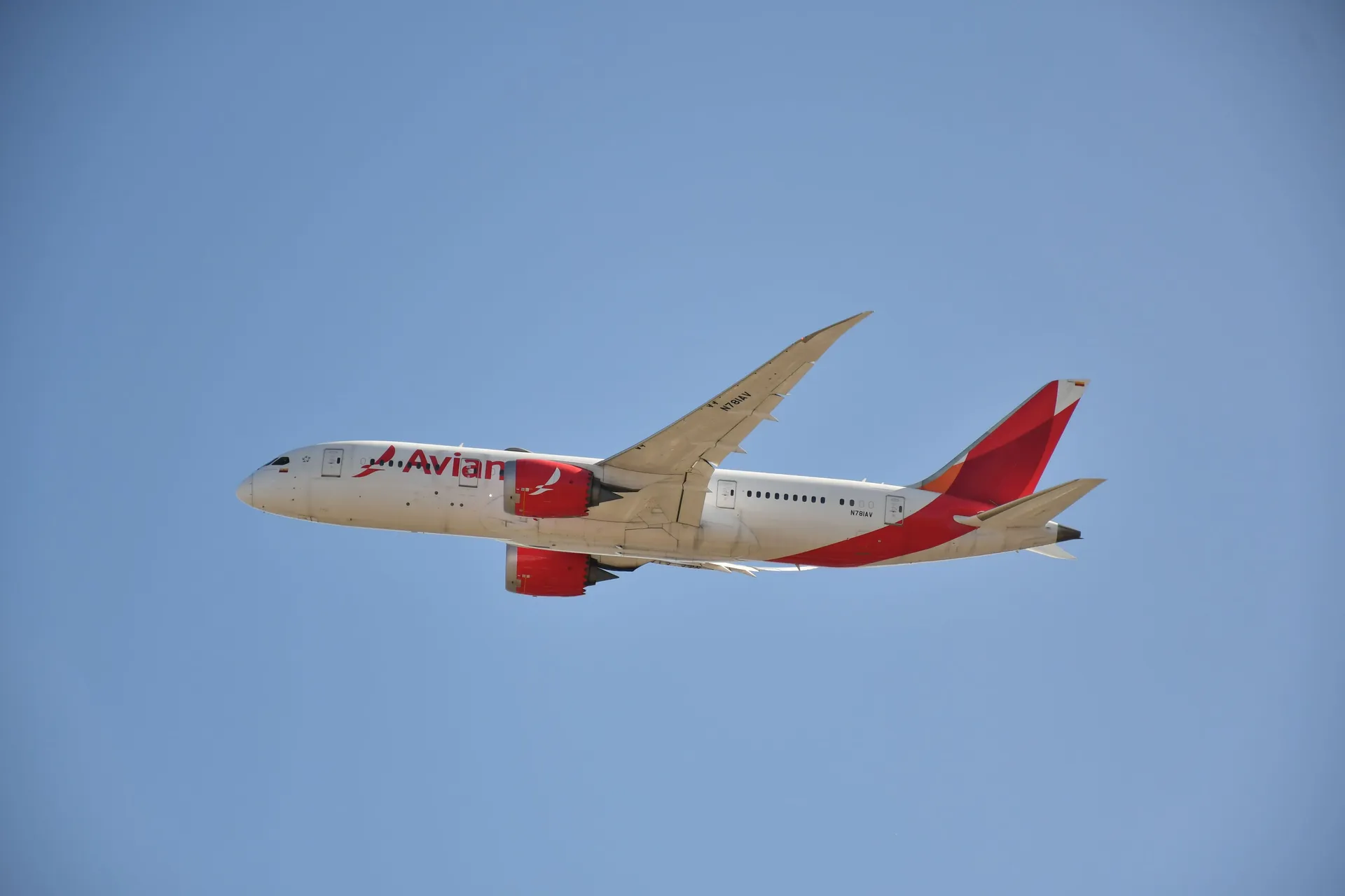 An Avianca Boeing 787 climbing away after takeoff against a clear blue sky