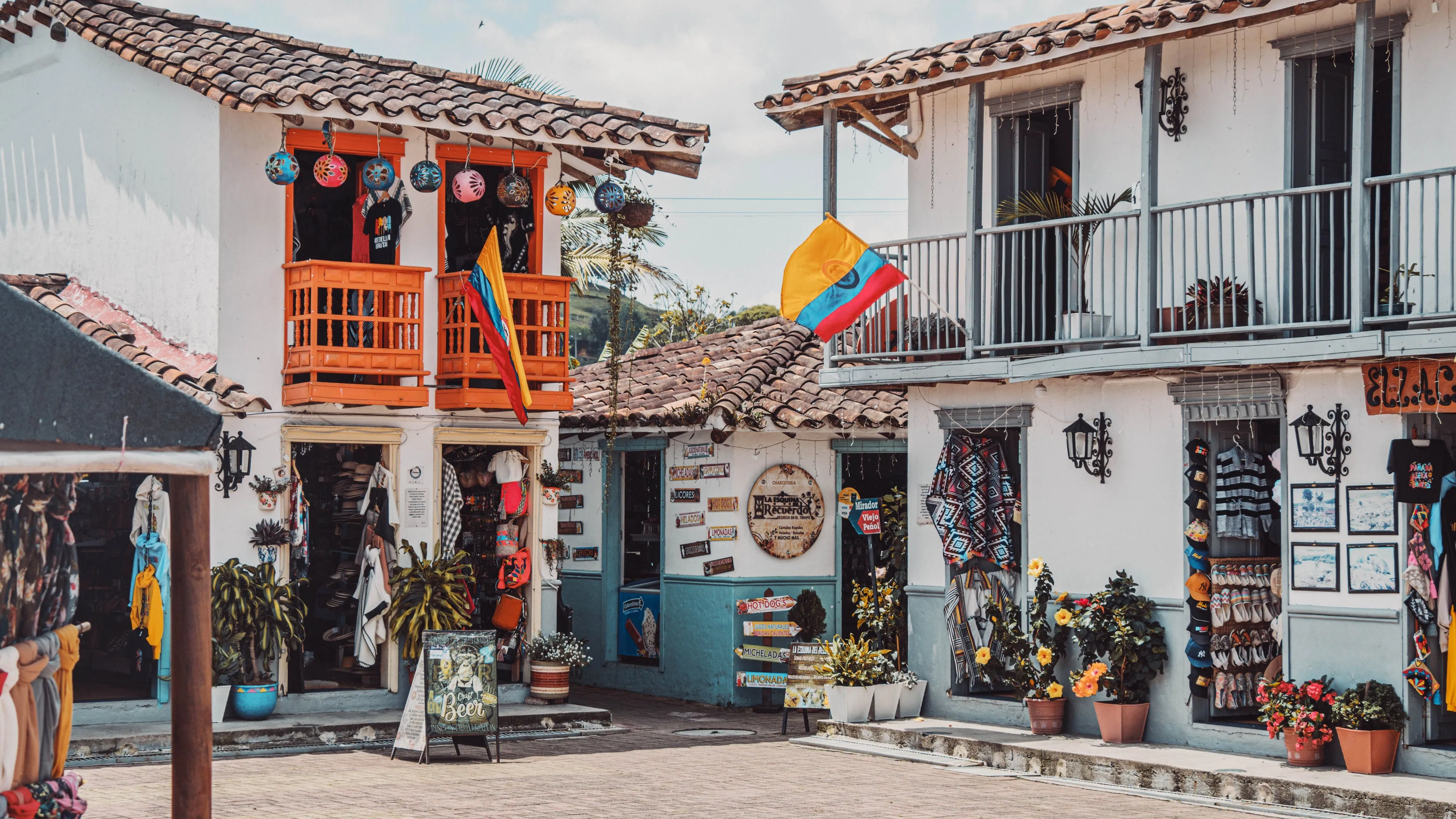 Craft shops and flag-draped balconies on a colonial street in a Colombian coffee town