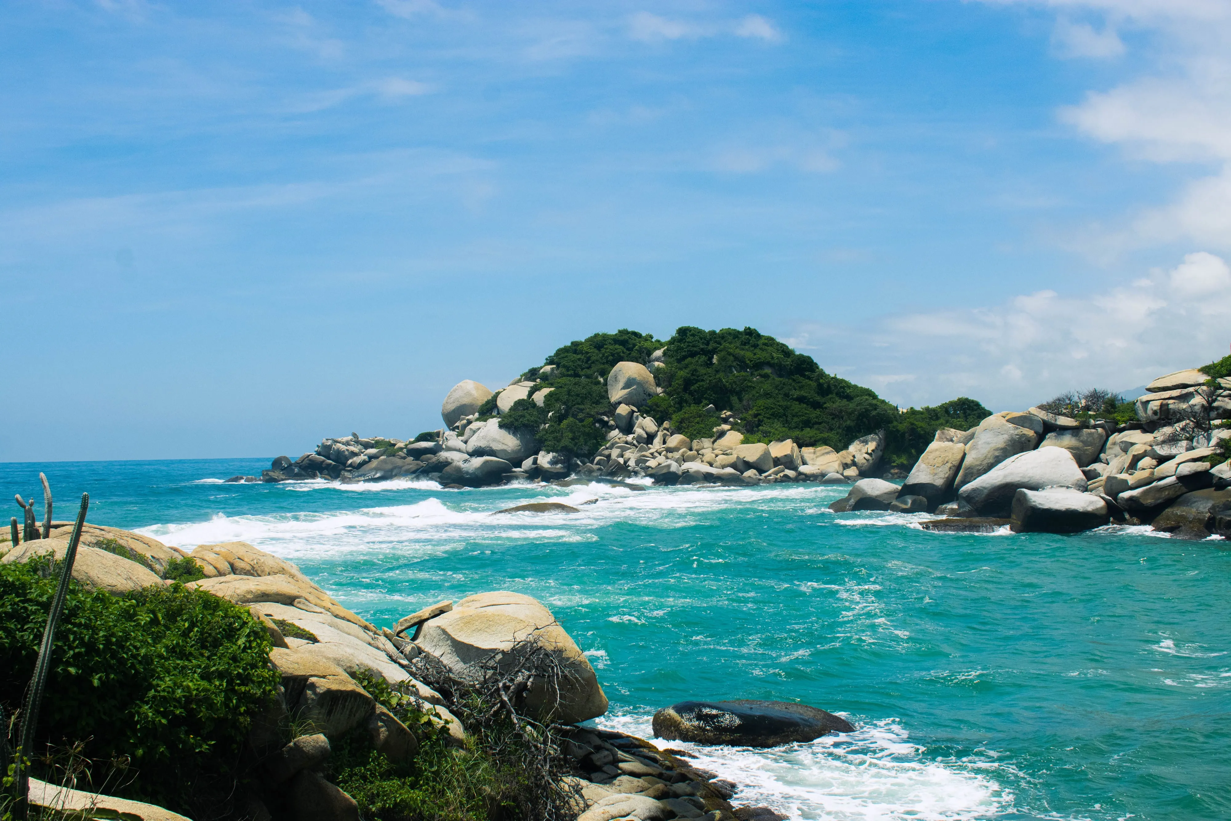 Turquoise water and jungle-covered mountains meeting the coastline in Tayrona National Park